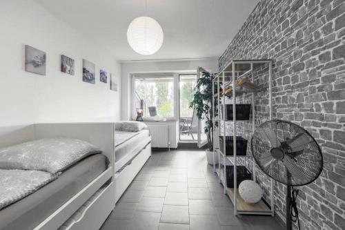 a bedroom with two beds and a brick wall at Top Equipped Netflix WLAN Landschaftspark in Duisburg