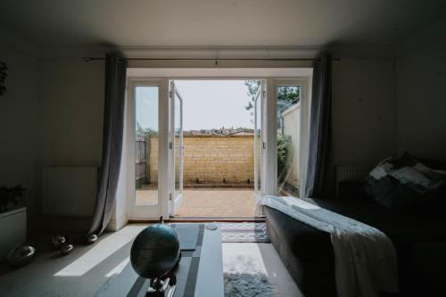 un soggiorno con divano e una grande porta scorrevole in vetro di Linen Cottage- Parking, LEDs, 4K TVs, 5G WIFI and more! a Bath