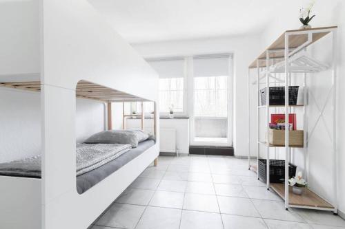 Habitación blanca con litera y suelo de baldosa. en Top Ausstattung Netflix WLAN Landschaftspark, en Duisburg