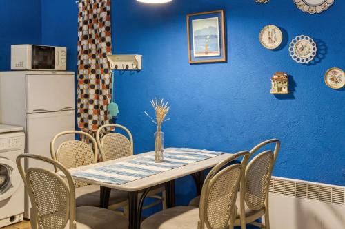 a dining room with a blue wall and a table and chairs at Casa Blava in Orriols