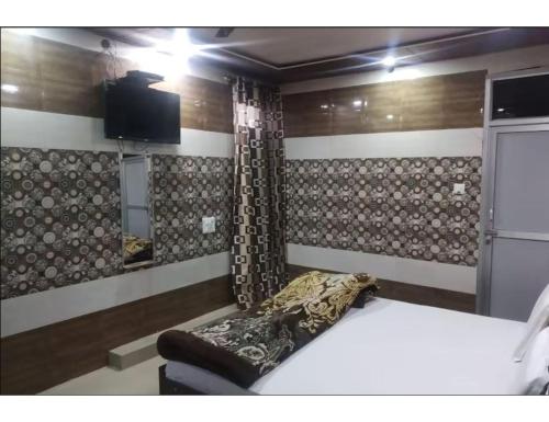 1 dormitorio con 1 cama y TV en la pared en Sharma Guest House, Naina Devi, Himachal Pradesh en Anandpur Sāhib
