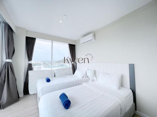 two white beds in a room with a window at KWEN Suites-Tanjung Aru InfinityPool Seaview/Airport View in Kota Kinabalu