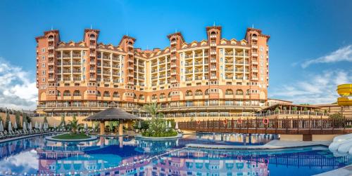 - un grand bâtiment avec une piscine en face dans l'établissement Villa Side Residence, à Sidé