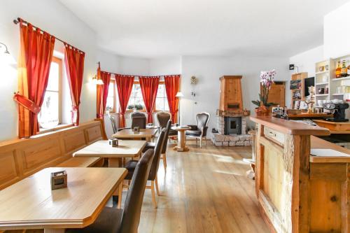 a restaurant with wooden tables and chairs and windows at Villa Ortensia in San Vigilio Di Marebbe