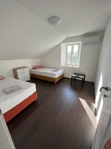 a large room with two beds and a window at Hostel Old School in Rijeka