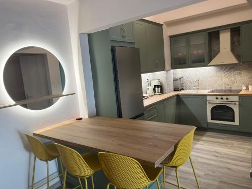 a kitchen with green cabinets and a wooden table and chairs at Loutraki apARTment in Loutraki