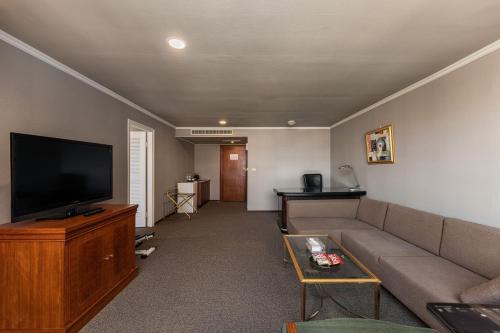 a living room with a couch and a flat screen tv at Hotel j-Metropolis in Hsinchu City