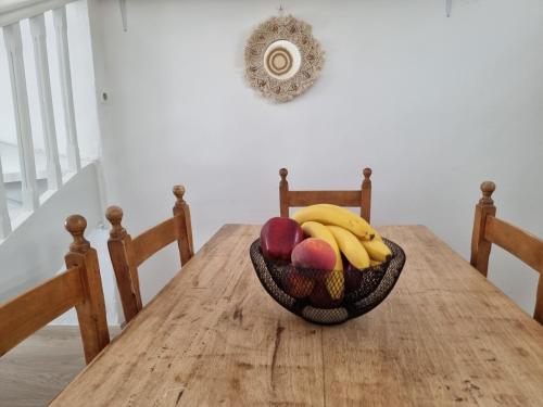 a bowl of fruit sitting on top of a wooden table at Anthoula Home Paros in Naousa