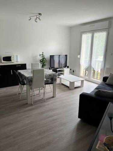 ein Wohnzimmer mit einem Tisch, Stühlen und einem Sofa in der Unterkunft Appartement in Cransac
