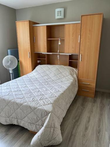 Schlafzimmer mit einem Bett und Holzschränken in der Unterkunft Appartement in Cransac