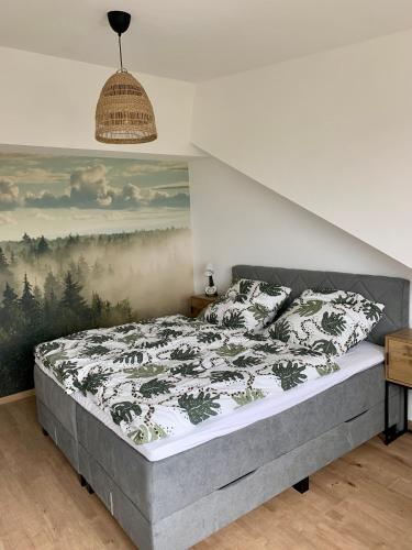 a bedroom with a bed with a painting on the wall at Ferienwohnungen mama ELVA in Leutkirch im Allgäu