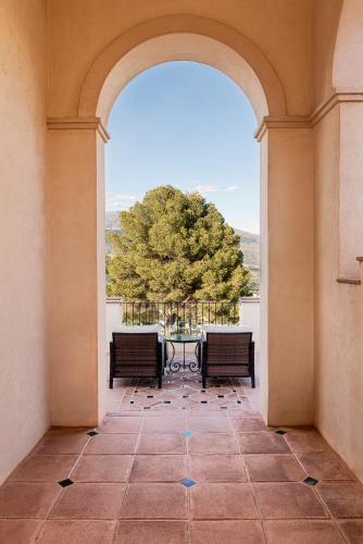 an archway with two benches and a table on a balcony at La Esperanza Granada Luxury Hacienda & Private Villa in Saleres