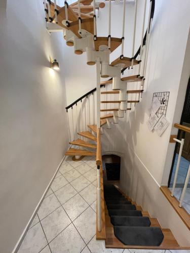 a staircase with wooden railings and a white stair case at Dorfel in Košice