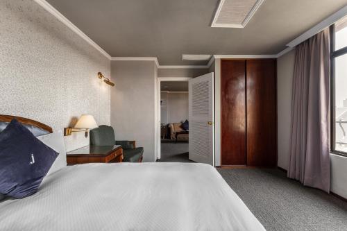 a bedroom with a large bed and a living room at Hotel j-Metropolis in Hsinchu City