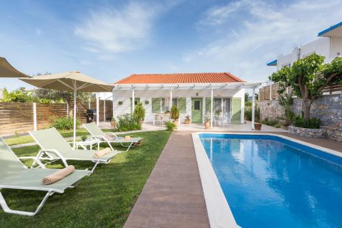 a villa with a swimming pool and patio furniture at Pelagias Villa in Kavros