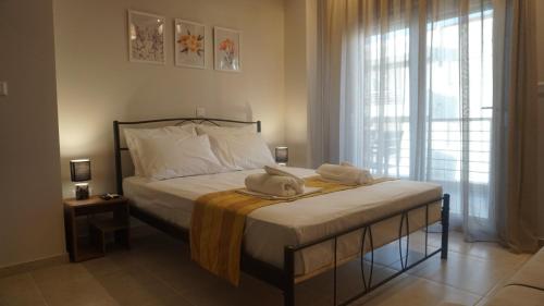 a bedroom with a bed with towels on it at Feather Apartments-Nea Moudania Halkidiki in Nea Moudania