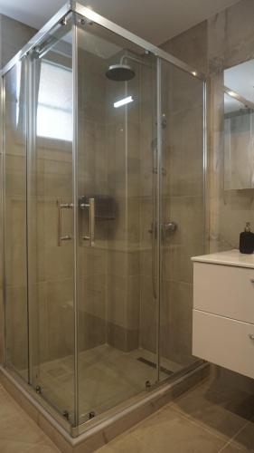 a shower with a glass door in a bathroom at Feather Apartments-Nea Moudania Halkidiki in Nea Moudania