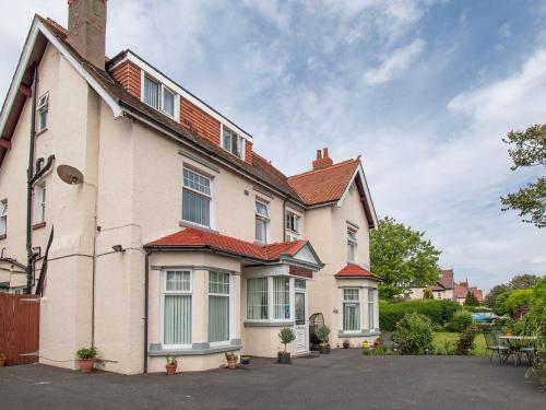 una gran casa blanca con techo rojo en Rosaire Guest House en Llandudno