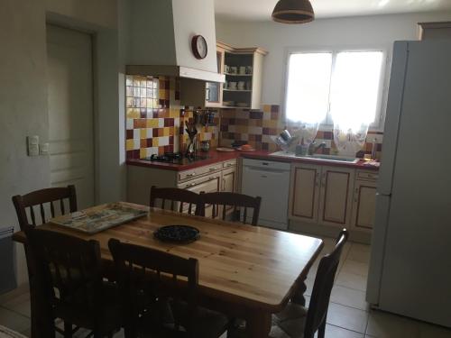 een keuken met een houten tafel en stoelen. bij Villa clochette in Les Arcs sur Argens