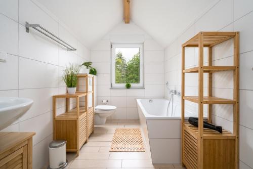 a bathroom with a tub and a toilet and a sink at Ferienhaus Alpaka in Plau am See