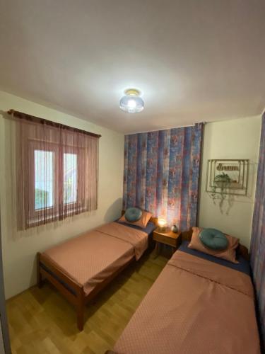 - une chambre avec 2 lits et une fenêtre dans l'établissement Stylish apartment with sea view, à Petrčane