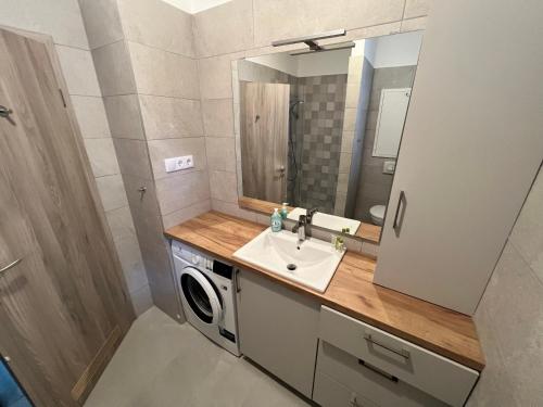 uma casa de banho com um lavatório e uma máquina de lavar roupa em Bez7 Apartman em Budapeste