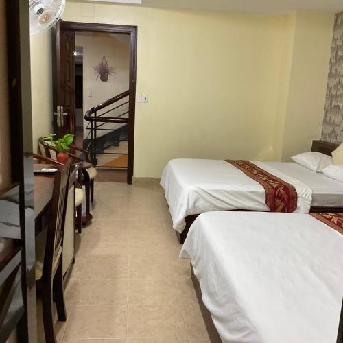 a hotel room with two beds and a staircase at Khách sạn Minh Châu - Hòa Hưng in Ho Chi Minh City