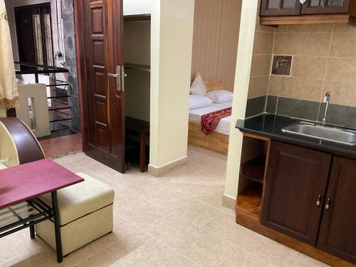 a kitchen with a sink and a room with a bed at Khách sạn Minh Châu - Hòa Hưng in Ho Chi Minh City