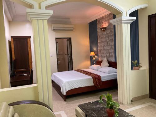 Habitación de hotel con cama y espejo en Khách sạn Minh Châu - Hòa Hưng, en Ho Chi Minh