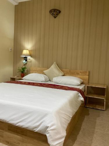 a bedroom with a large bed with white sheets at Khách sạn Minh Châu - Hòa Hưng in Ho Chi Minh City