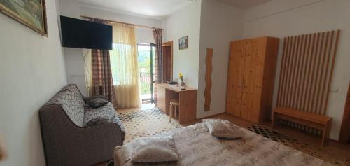 un salon avec un canapé et une télévision dans l'établissement Pensiunea TOP DEMAC, à Slănic