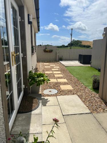 a garden with a walkway next to a house at Smythe Cottage in Kirkistown