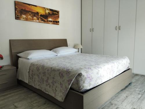 een slaapkamer met een groot bed met witte kussens bij Appartamento Miro in San Pellegrino Terme