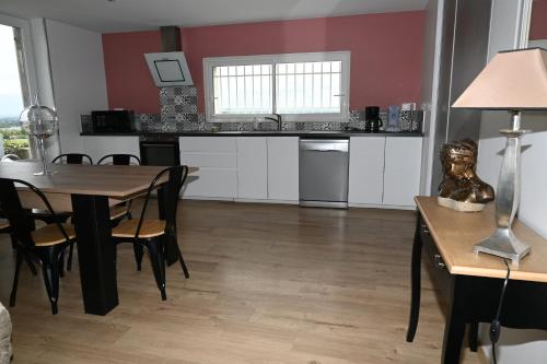 une cuisine et une salle à manger avec une table et des chaises dans l'établissement Gite de Daspe, à Beaupuy