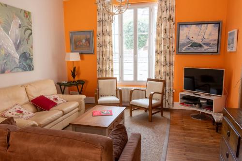ein Wohnzimmer mit einem Sofa und einem TV in der Unterkunft Maison sablaise face à la Grande Plage - classée 4 in Les Sables-dʼOlonne