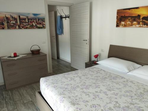 a bedroom with a large bed and a dresser at Appartamento Miro in San Pellegrino Terme