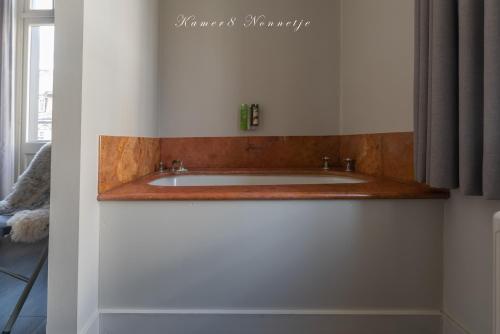 a bathroom with a sink in a white cabinet at Hotel Bonne Auberge (Adults Only) in De Haan