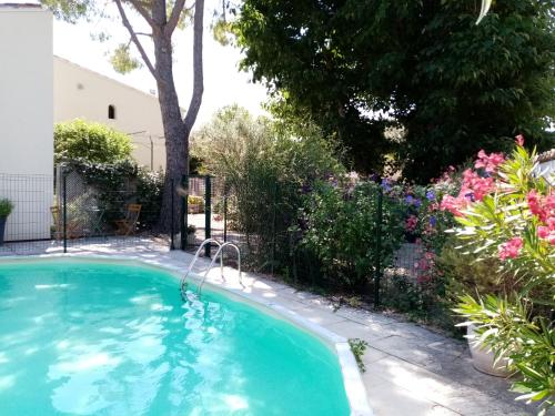 uma piscina num quintal com flores em Gite du Piboulet em Les Granges-Gontardes