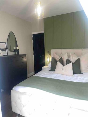 a bedroom with a large bed and a mirror at Churchview Apartments in Seaham