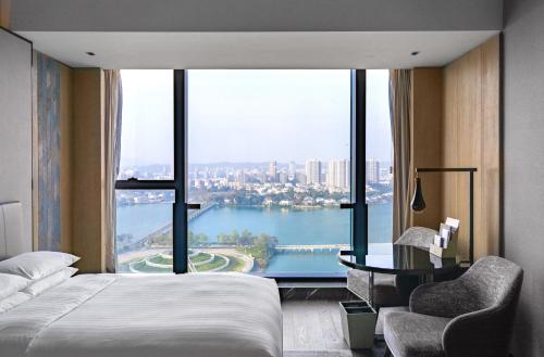 a hotel room with a bed and a large window at Marriott Nanjing South Hotel in Jiangning