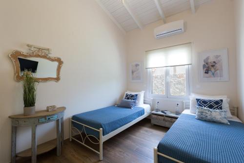 a bedroom with two beds and a mirror at Pelagias Villa in Kavros