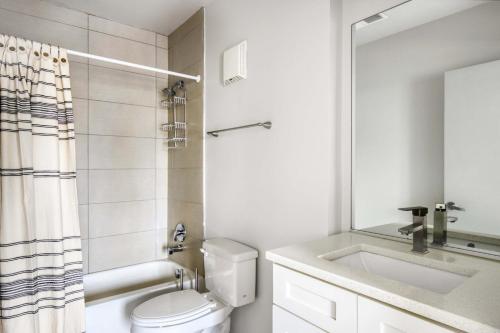 a bathroom with a toilet and a sink and a mirror at South Loop 1br nr L Grant Park CHI-807 in Chicago