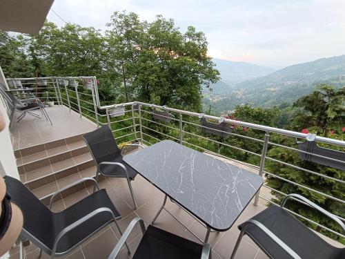 a table and chairs on a balcony with a view at Nahorevska vikendica in Sarajevo