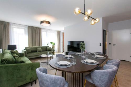 a living room with a table and chairs and a couch at City Center - Długa Grobla by Apartmore in Gdańsk