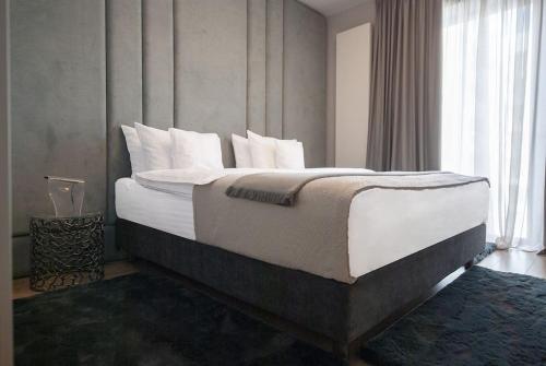 ein Schlafzimmer mit einem großen Bett mit weißer Bettwäsche und Kissen in der Unterkunft Shades of Grey 124 in Bukarest
