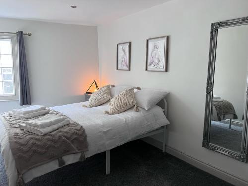 Schlafzimmer mit einem Bett und einem Spiegel in der Unterkunft Little Pilgrims Retreat in St Dunstans, Canterbury in Kent