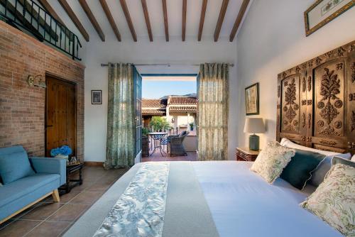 a bedroom with a bed and a couch and a window at La Esperanza Granada Luxury Hacienda & Private Villa in Saleres