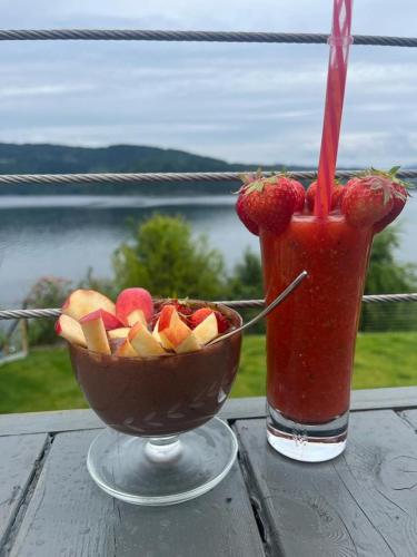a drink and a bowl of fruit on a table at Bergen Sunrise Terrace Apartment in Bergen