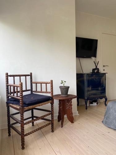 une chambre avec une chaise, une table et une télévision dans l'établissement Charming rooms in green area, à Laethem-Saint-Martin