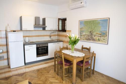 eine Küche mit einem Tisch und einer Blumenvase darauf in der Unterkunft Apartment Lavanda in Zadar